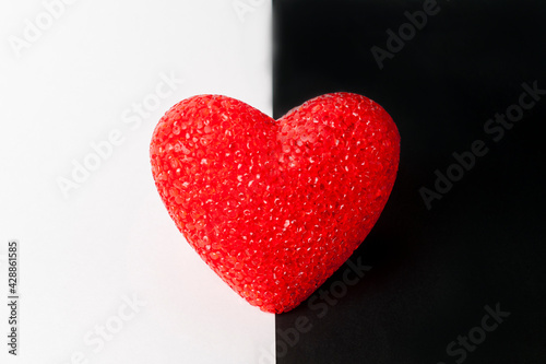 Red heart on black and white background. The heart is in the middle.