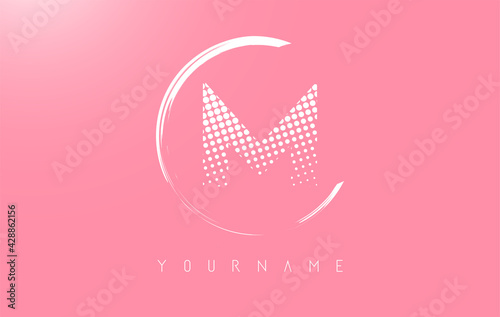 White M letter logo design with white dots and white circle frame on pink background.