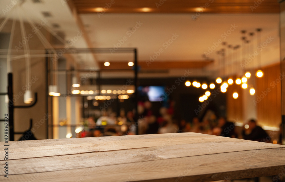 image of wooden table in front of abstract blurred background of restaurant lights image of wooden table in front of abstract blurred background of restaurant lights