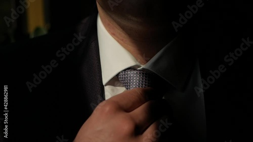 businessman adjusting tie.a man in a suit straightens his tie