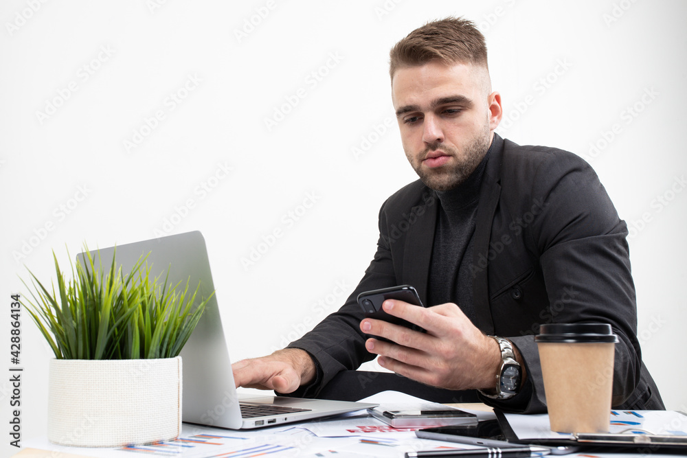 A guy in business clothes is working on a laptop at a table on a white background A guy in business clothes is working on a laptop at a table on a white background