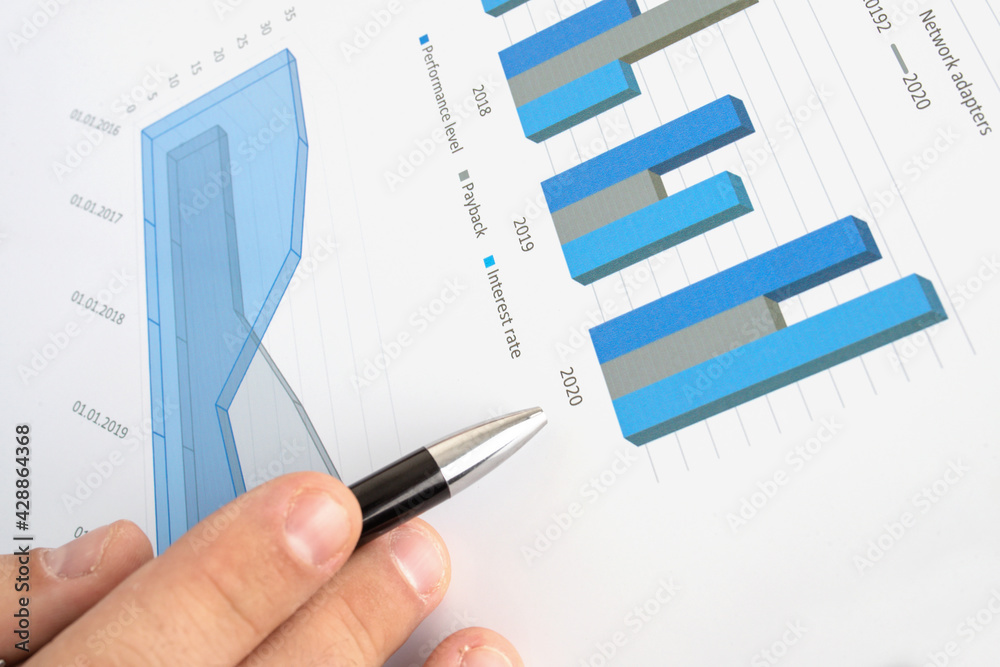 The guy studies the dynamics of business development on charts. Close-up