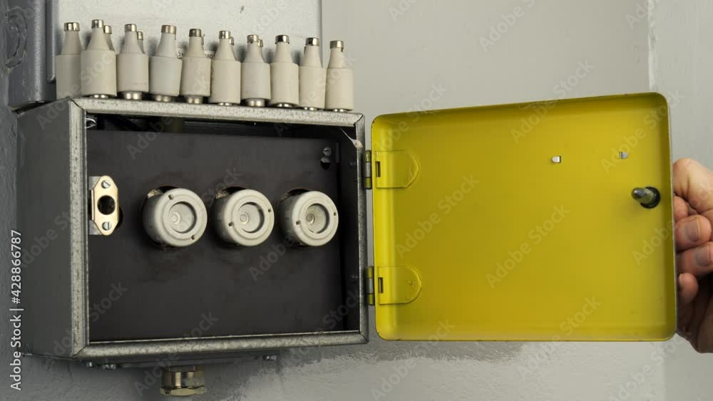 open-a-old-fuse-box-with-three-ceramic-fuses-a-metallic-cabinet-opens