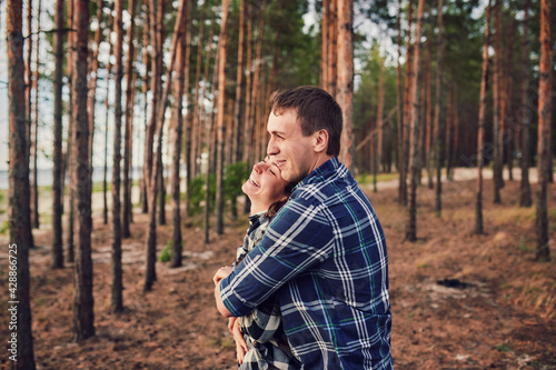 young couple smiling at each other during a romantic date in the forest