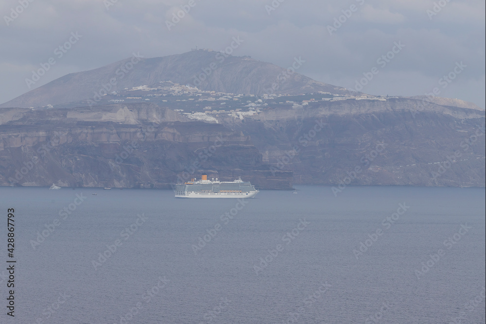 View of the sea and coast on the island of Santorini caldera in Greece. The background is a blue sky.