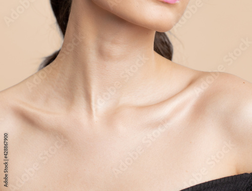 Women neck and shoulders on nude background © &Co Stock Images