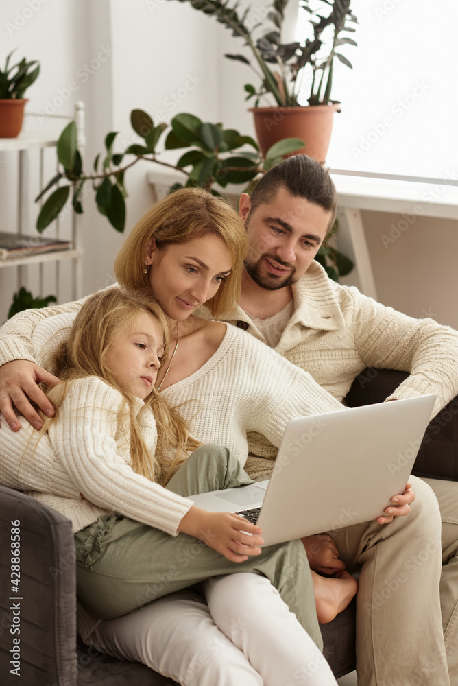 family with baby looking at laptop