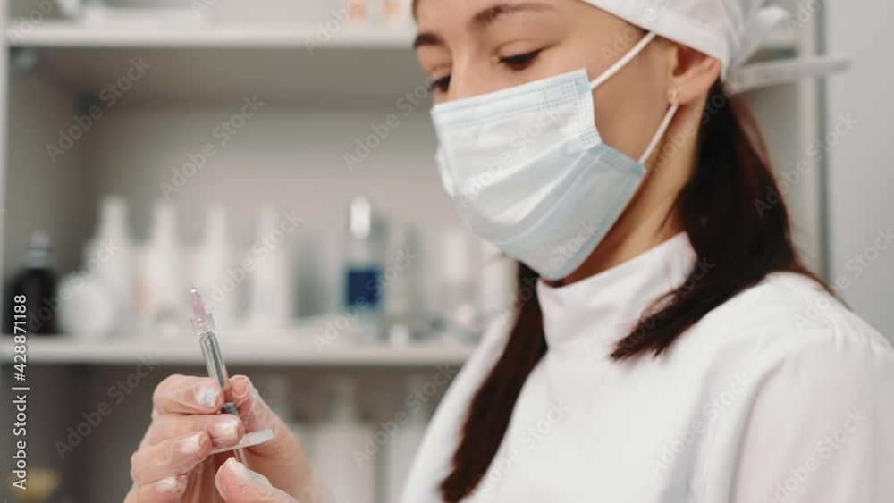 Beauty clinic. The beautician holds a syringe with Botox for further injections. The doctor examines the device Beauty clinic. The beautician holds a syringe with Botox for further injections. The doctor examines the device