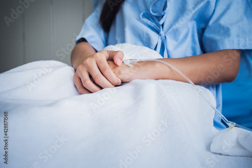 Close up images of The patient's hand Which has a saline solution attached to the back of the hand, at hospital concept to health care and health insurance