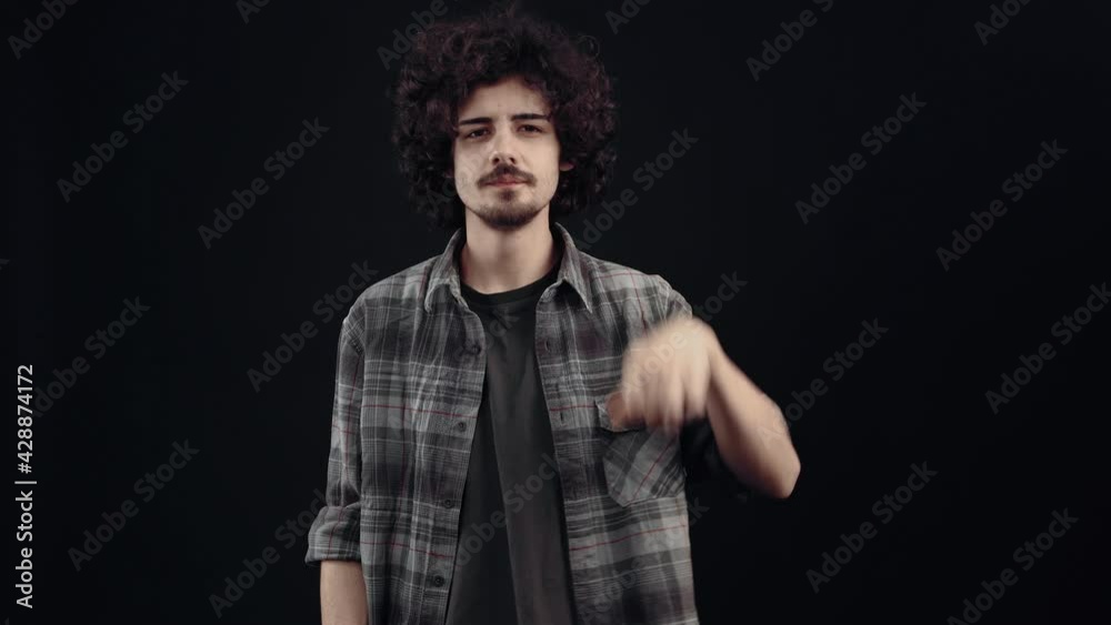 Charismatic, mysterious young man, he puts his index finger to his lips keeping the secret and throws the imaginary keys to prevent its spread. Isolated on black background, Concept of life. People's Charismatic, mysterious young man, he puts his index finger to his lips keeping the secret and throws the imaginary keys to prevent its spread. Isolated on black background, Concept of life. People's