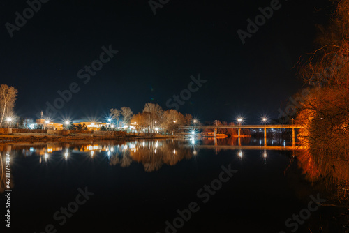 View of the bridge over the river Seversky Donets from the side of the Svyatogorsk Lavra at night © Yevhen