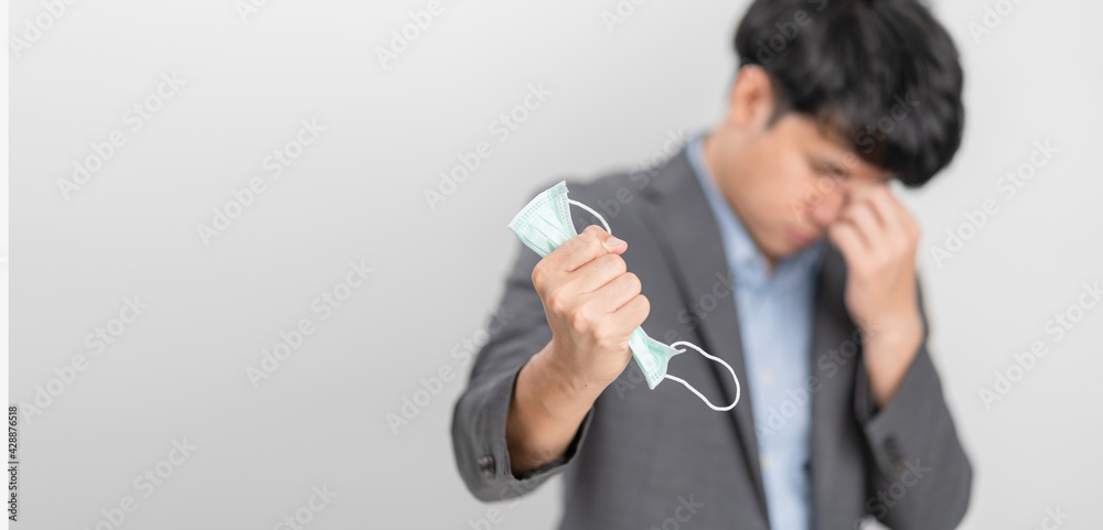 Depress Businessman holding an anti virus protection mask to prevent others from corona COVID-19 and SARS cov 2 infection. Protection versus viruses and infection. Depress Businessman holding an anti virus protection mask to prevent others from corona COVID-19 and SARS cov 2 infection. Protection versus viruses and infection.