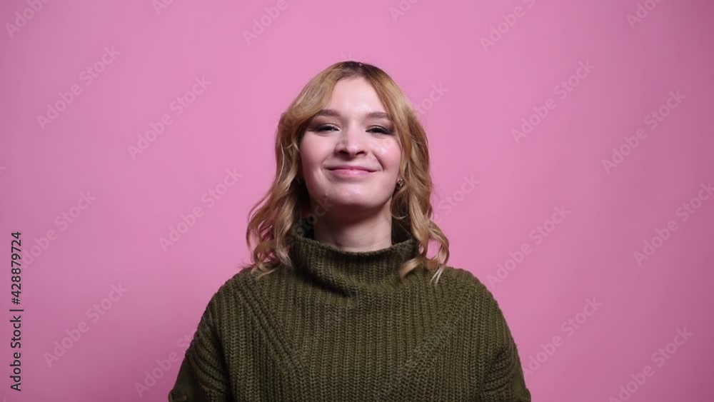 The woman is angry and aggressive. Video on a pink background in the studio The woman is angry and aggressive. Video on a pink background in the studio