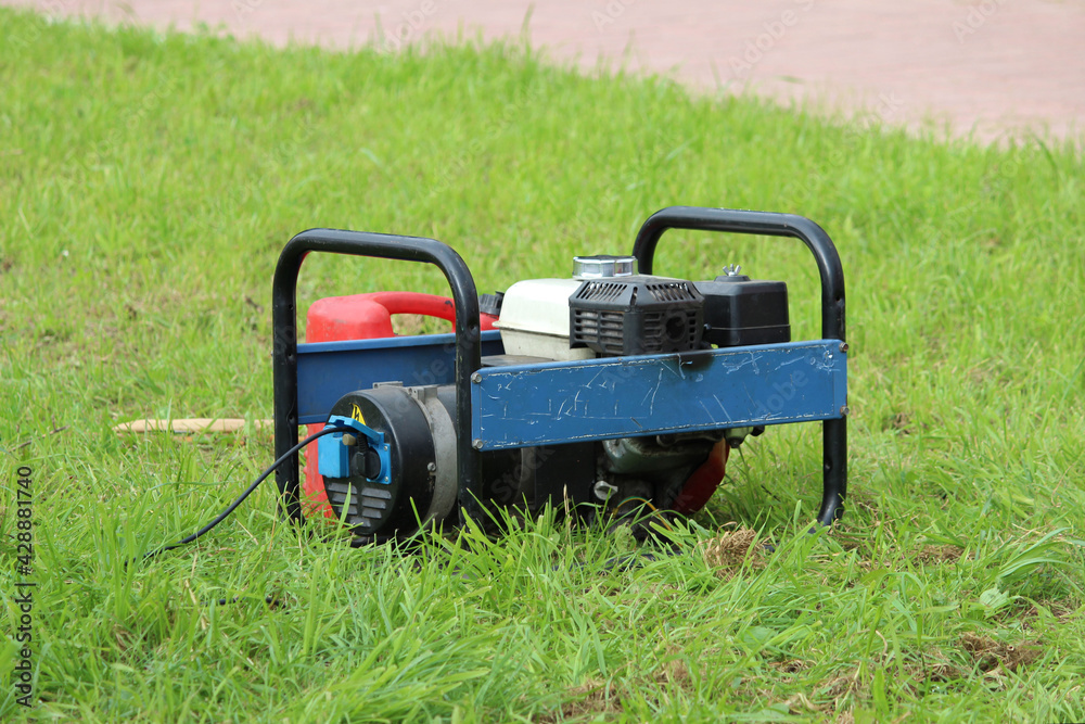 blue and red small power generator stands near a street stage on the grass during City Day entertainment blue and red small power generator stands near a street stage on the grass during City Day entertainment