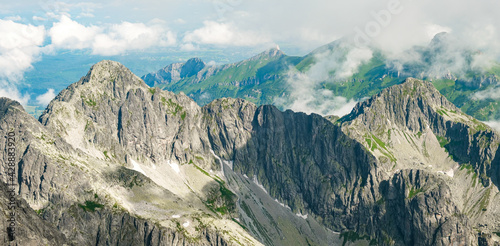 Panoramic view of Tatra mountain peaks and rocks covered with clouds 