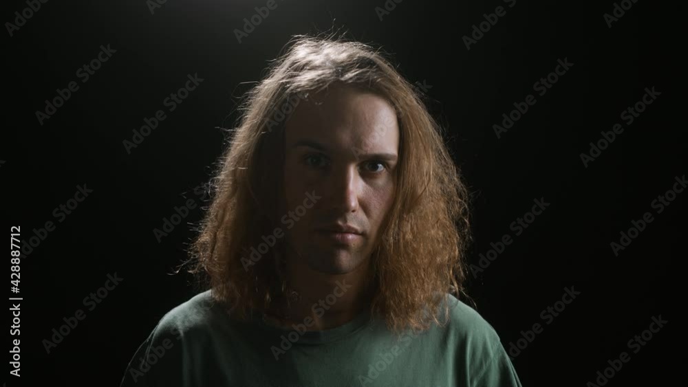 Portrait of Man Surfer raising one eyebrow, looking in camera. Handsome Surfing Man With Long Hair in modern studio, cyber sport trainer gamer Portrait of Man Surfer raising one eyebrow, looking in camera. Handsome Surfing Man With Long Hair in modern studio, cyber sport trainer gamer