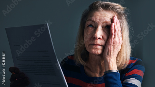 Desperate elderly woman reading eviction notice. High quality photo