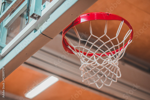 view of a net on a baksketball table viewed from under the basket in a gym or stadium.