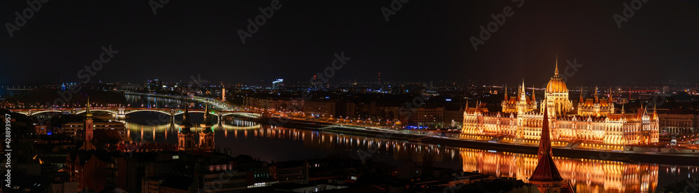 Night Budapest, Parliament against the background of the night city, reflection of lights in the river, panorama of the city