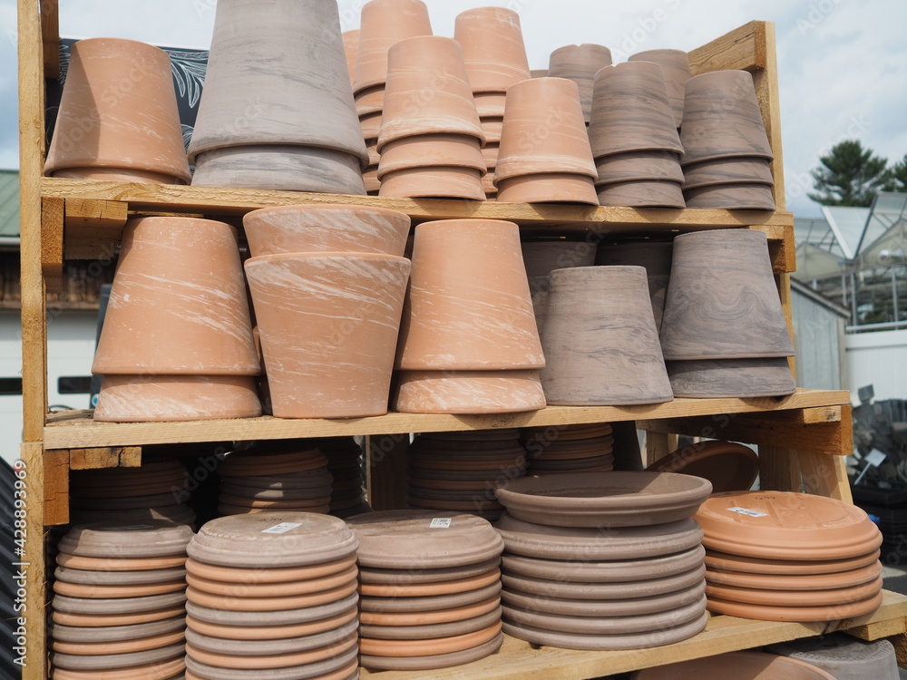 The clay pottery are upside on the shelves at the garden center. The clay pottery are upside on the shelves at the garden center.