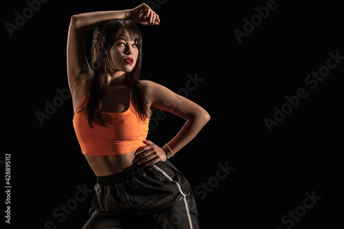 Slika na platnu Young female dancer posing on black background