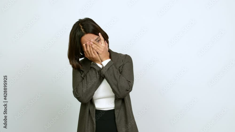 Young latin woman covering eyes by hands and looking through the fingers over isolated background Young latin woman covering eyes by hands and looking through the fingers over isolated background
