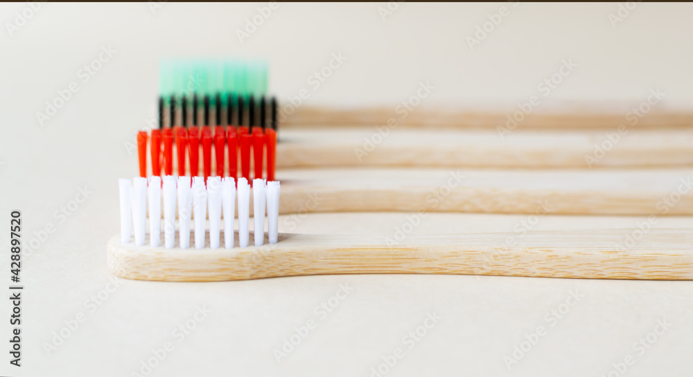 Four multi-colored bamboo toothbrushes . Eco friendly stuff concept. Copy space. Horizontal orientation. Selective focus. Four multi-colored bamboo toothbrushes . Eco friendly stuff concept. Copy space. Horizontal orientation. Selective focus.
