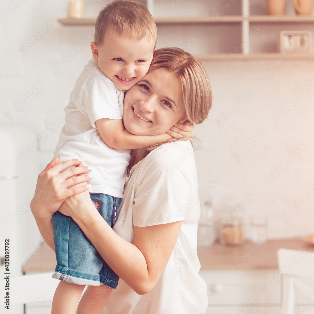 Son with mom are cutting vegetables on salad in kitchen and hugging. Happy family. Son with mom are cutting vegetables on salad in kitchen and hugging. Happy family.