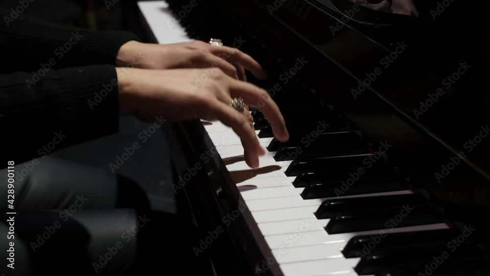 Woman two hands plays gentle classical music on a grand piano. Professional pianist
