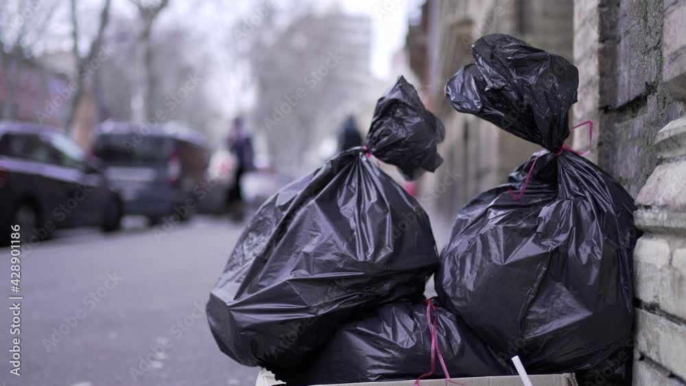 Trash at side road in city for pick-up. Pollution black garbage trash