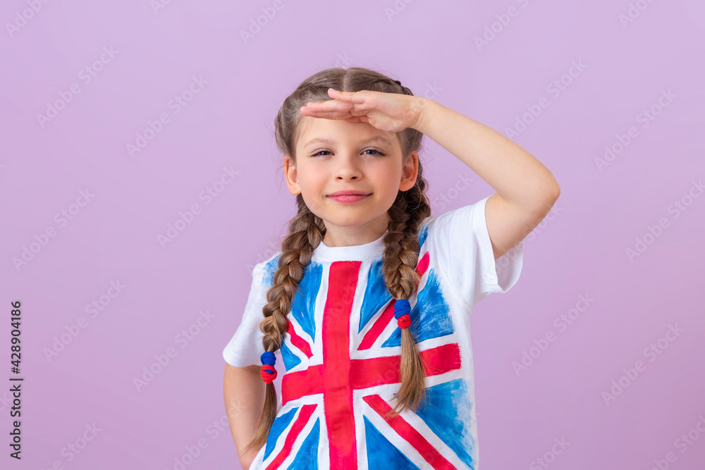 A little girl with pigtails and an image of the English flag looks into the distance. A little girl with pigtails and an image of the English flag looks into the distance.