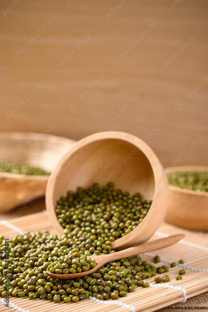 Pile of mung bean seeds in a wooden spoon and bowl, Food ingredients in Asian cuisine and produce mung bean sprout Pile of mung bean seeds in a wooden spoon and bowl, Food ingredients in Asian cuisine and produce mung bean sprout