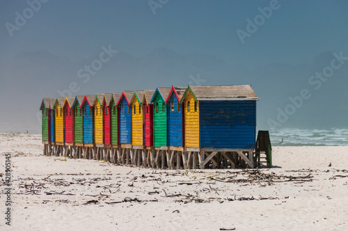 Famous colorful beach houses in Muizenberg near Cape Town, South Africa with Hottentots Holland mountains in the background. photo