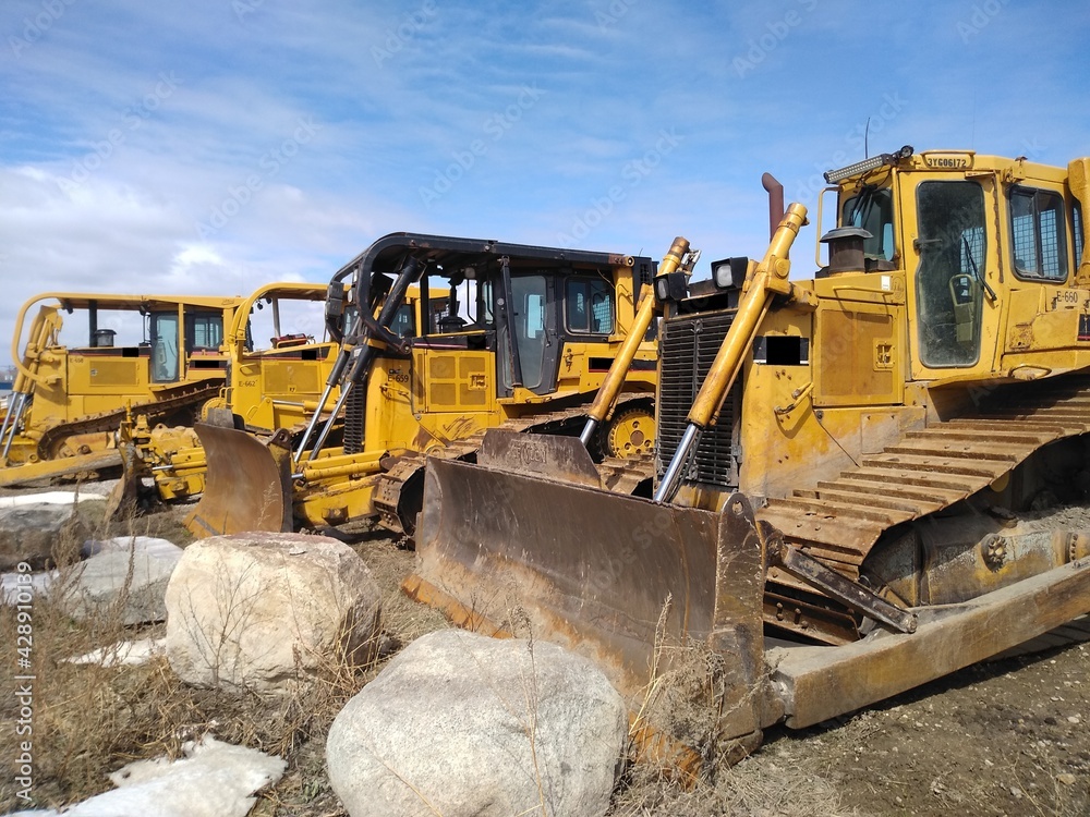Obraz premium Road construction equipment: yellow caterpillar bulldozers