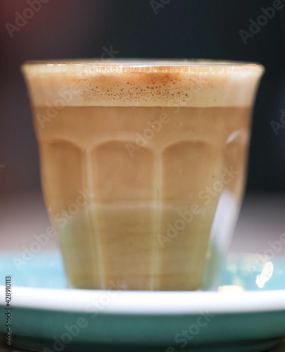 decorated glass of Coffee Piccolo Latte on a white table in a Sydney Cafe NSW Australia