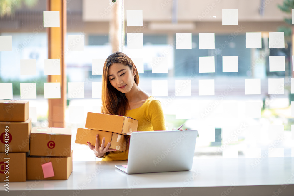 Portrait of Starting small businesses SME owners female entrepreneurs working, box and check online orders to prepare to pack the boxes, sell to customers, sme business ideas online.
