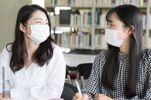 マスクを付けて会話をする大学生 photo