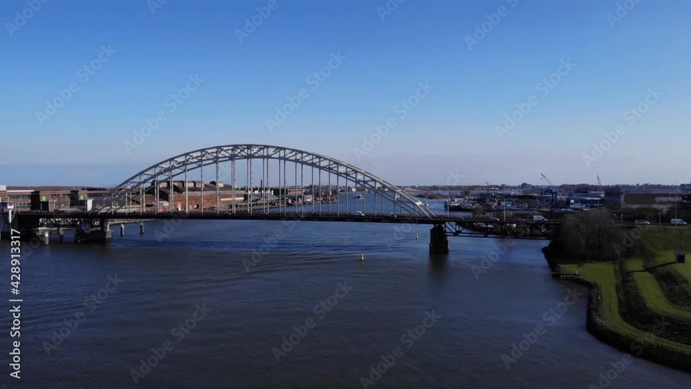 Arch Bridge Over Noord River With A View Of Hendrik-Ido-Ambacht Town In South Holland, Netherlands. - aerial Arch Bridge Over Noord River With A View Of Hendrik-Ido-Ambacht Town In South Holland, Netherlands. - aerial