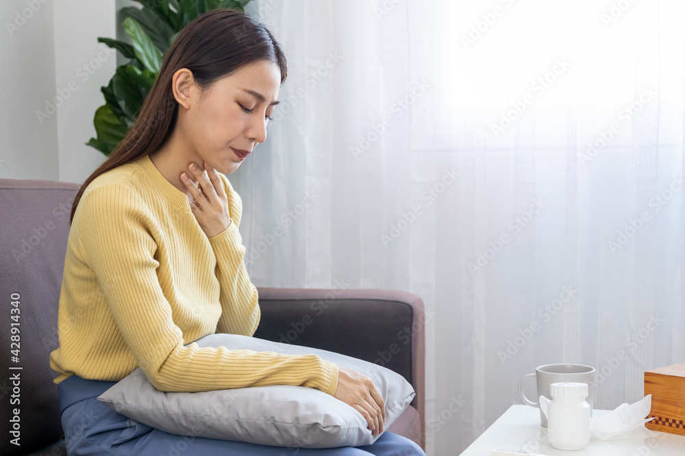 Cough, Sore throat asian young woman, girl touching neck and feeling pain or sickness, have a fever, flu or ill on sofa bed, couch at home. Health, cold seasonal influenza person and virus concept. Cough, Sore throat asian young woman, girl touching neck and feeling pain or sickness, have a fever, flu or ill on sofa bed, couch at home. Health, cold seasonal influenza person and virus concept.