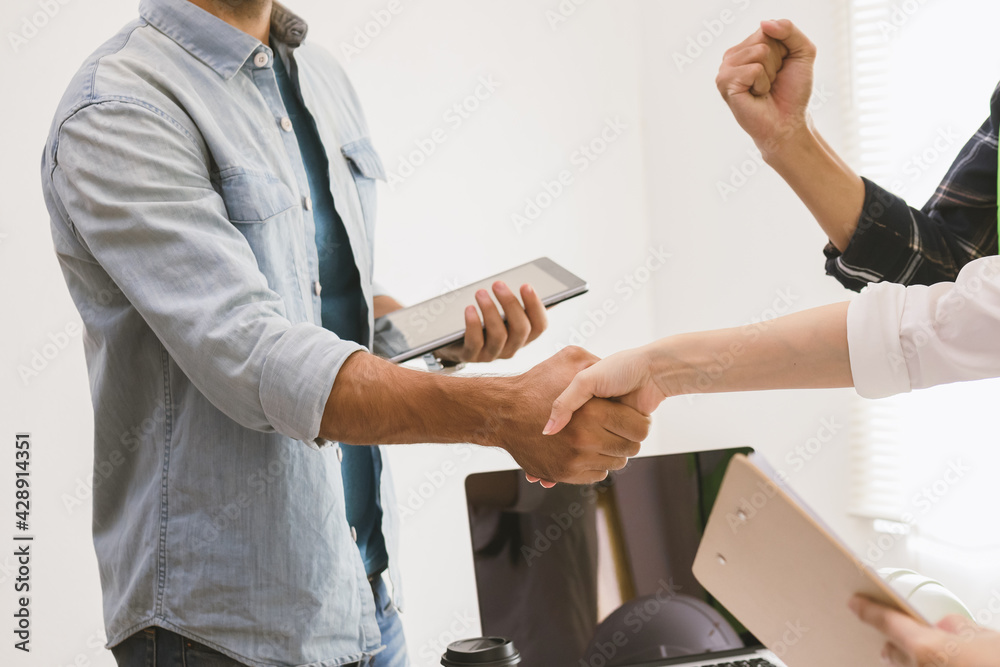 Obraz premium Close up hand of group, team young contractor, engineer handshake with partnership, customer after agreement to work together at the site, workplace, office. Business success concept.