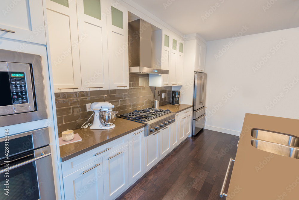 Fototapeta premium Modern, bright, clean, kitchen interior with stainless steel appliances in a luxury house