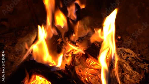 Flames burning around a log in a fireplace. Macro close up of a winter night photo