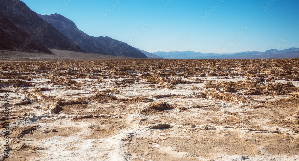Salt flats and mud cracks in Death Valley National Park. Badwater Basin and Black Mountains