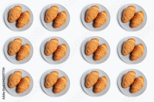 Pattern of two croissants in grey plate isolated on white background.