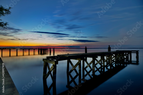 beautiful sunset colors broken down piers © Joy