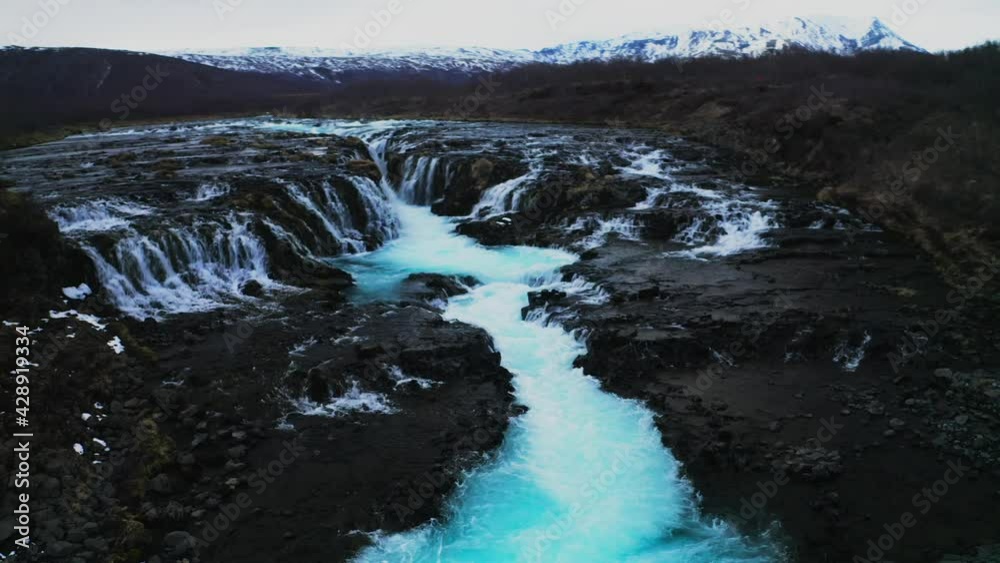 Turquoise Blue River Water From Bruarfoss Waterfall Cascade In Brekkuskogur, Iceland. aerial drone, rotating shot