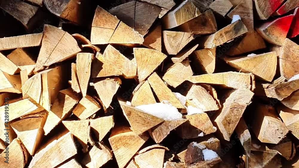 Vie over a pile of logs being stacked in triangle shapes Vie over a pile of logs being stacked in triangle shapes