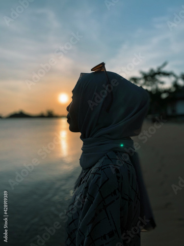 Medium Shot Woman in front of Sunset at Beautiful Beach
