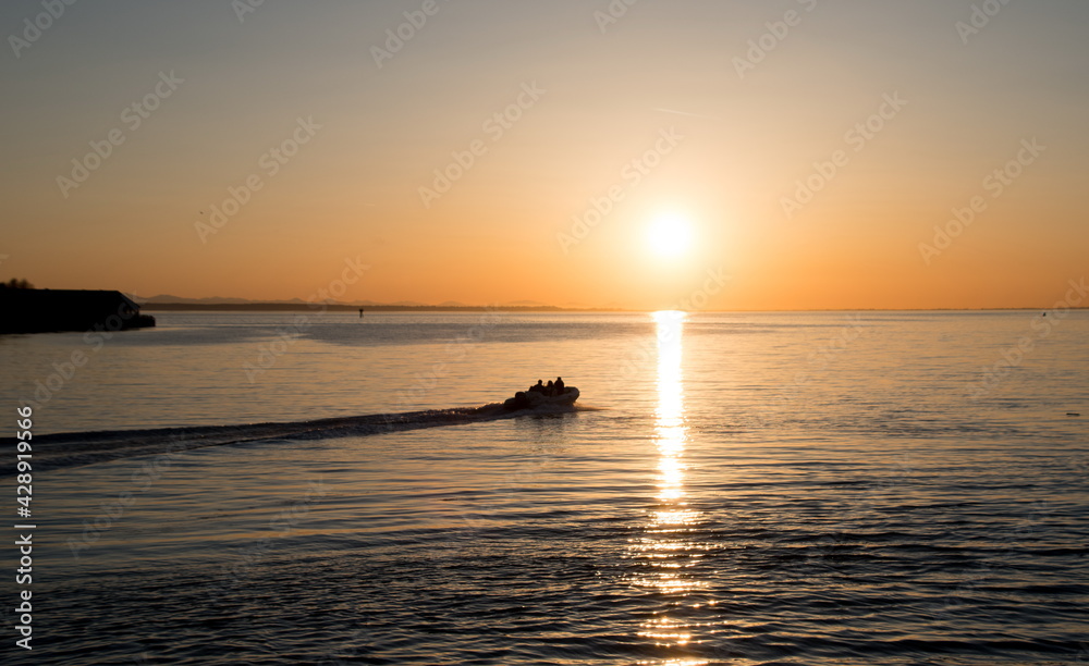Motorboat riding into sunset in Semiahmoo Bay Motorboat riding into sunset in Semiahmoo Bay