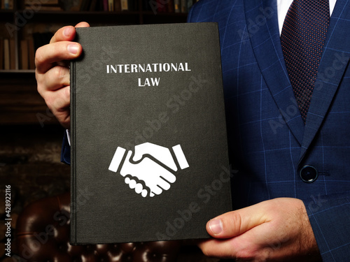 Book with title INTERNATIONAL LAW . The international law is enshrined in conventions, treaties and standards